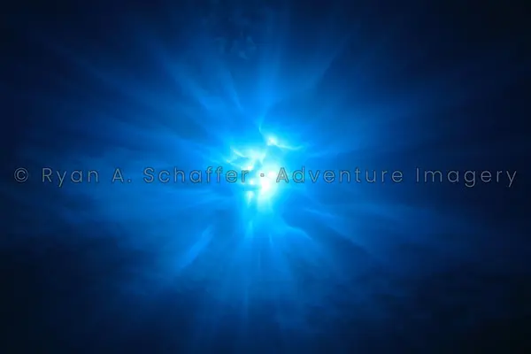 Sunlight radiating through deep blue water.